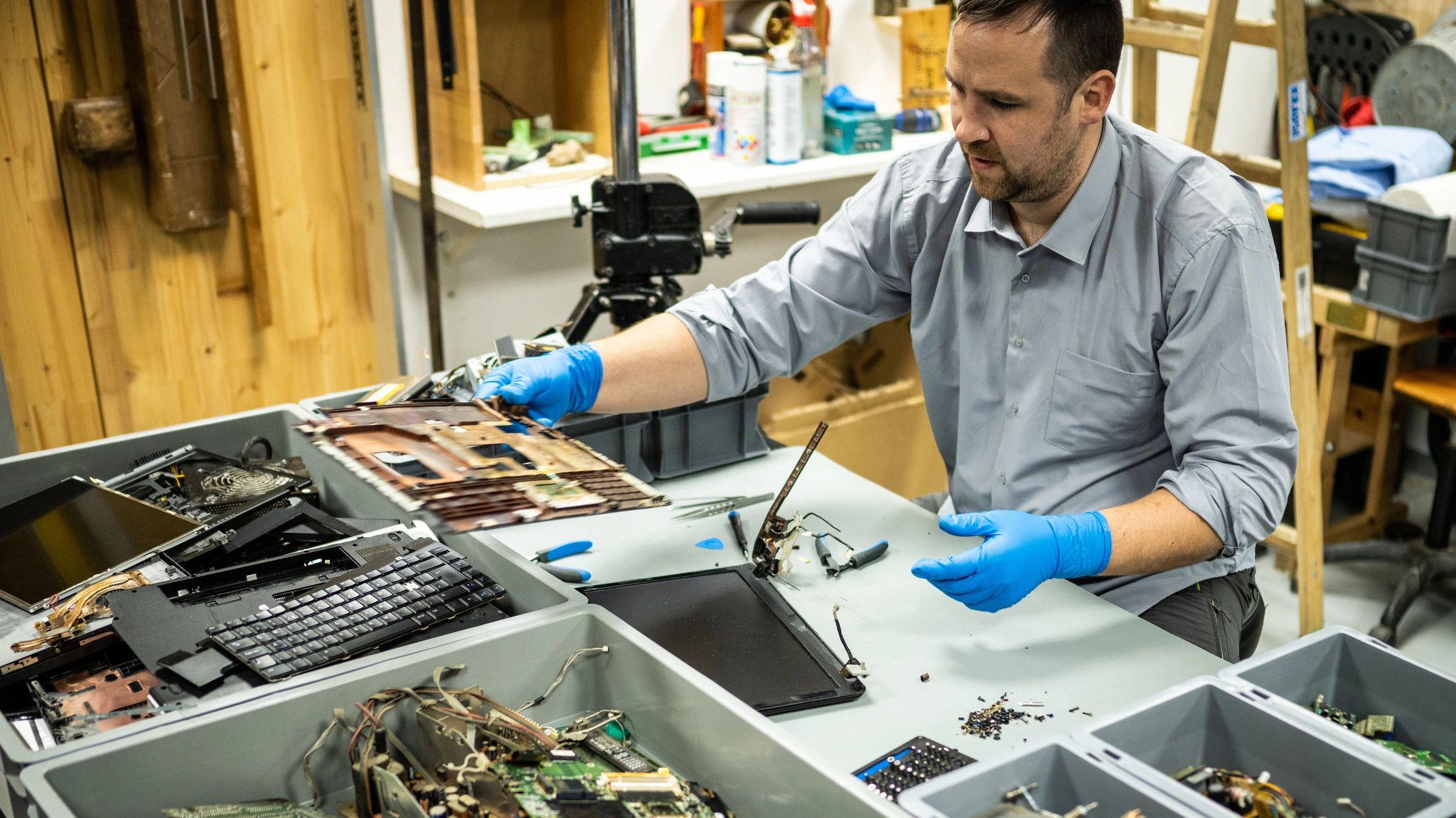 Technician repairing a laptop in a workshop